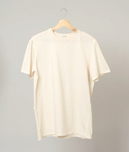 Classic unbleached and undyed organic cotton T-shirt on plain background.