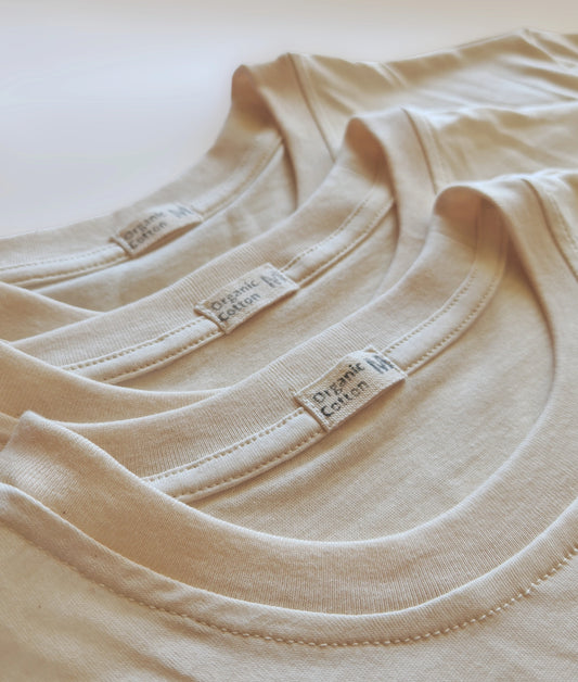 Three-pack of organic cotton T-shirts, unbleached and undyed, neatly folded.