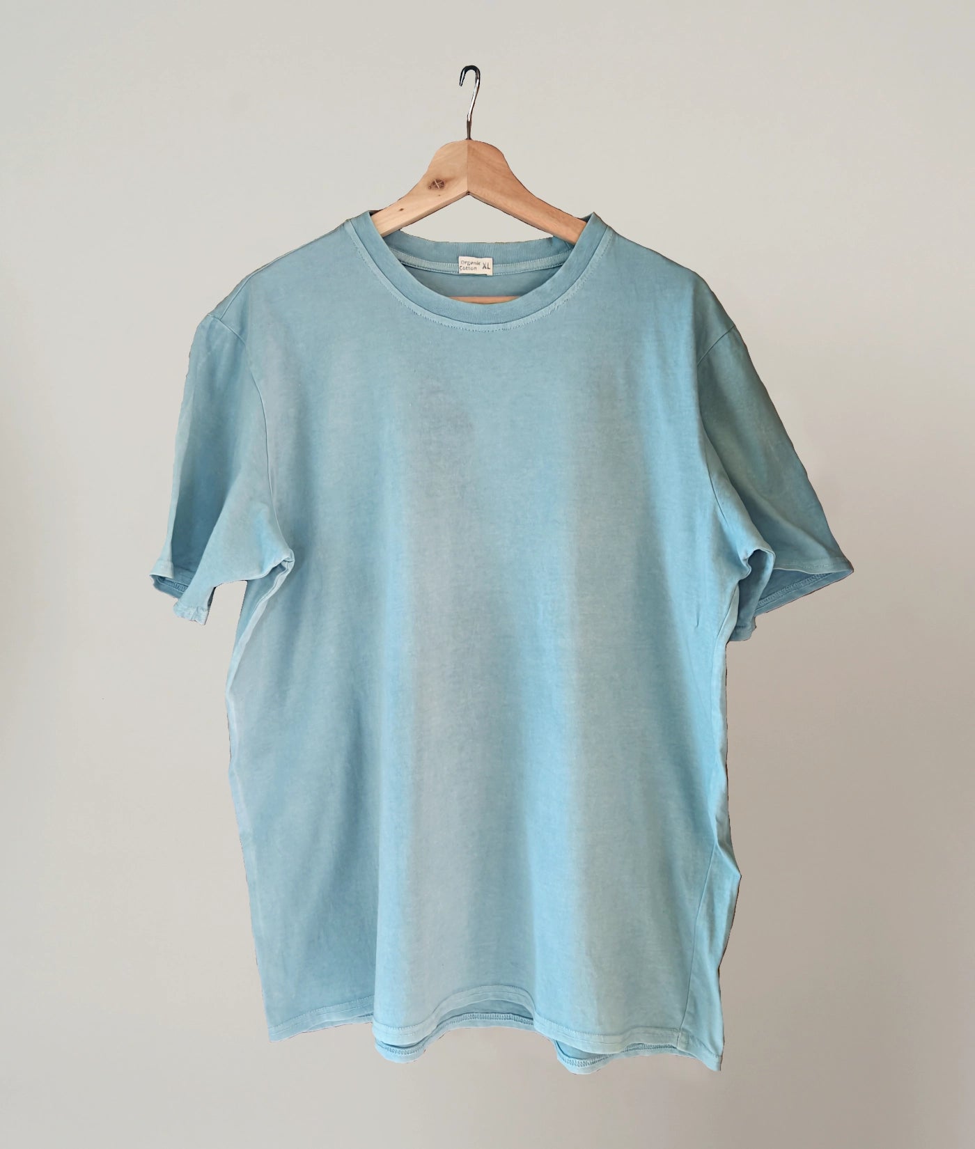 Natural indigo dyed organic cotton T-shirt on plain background.