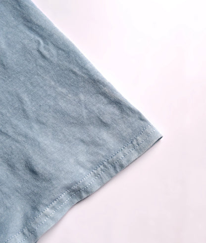 Detail of stitched hem on natural indigo dyed organic cotton T-shirt.