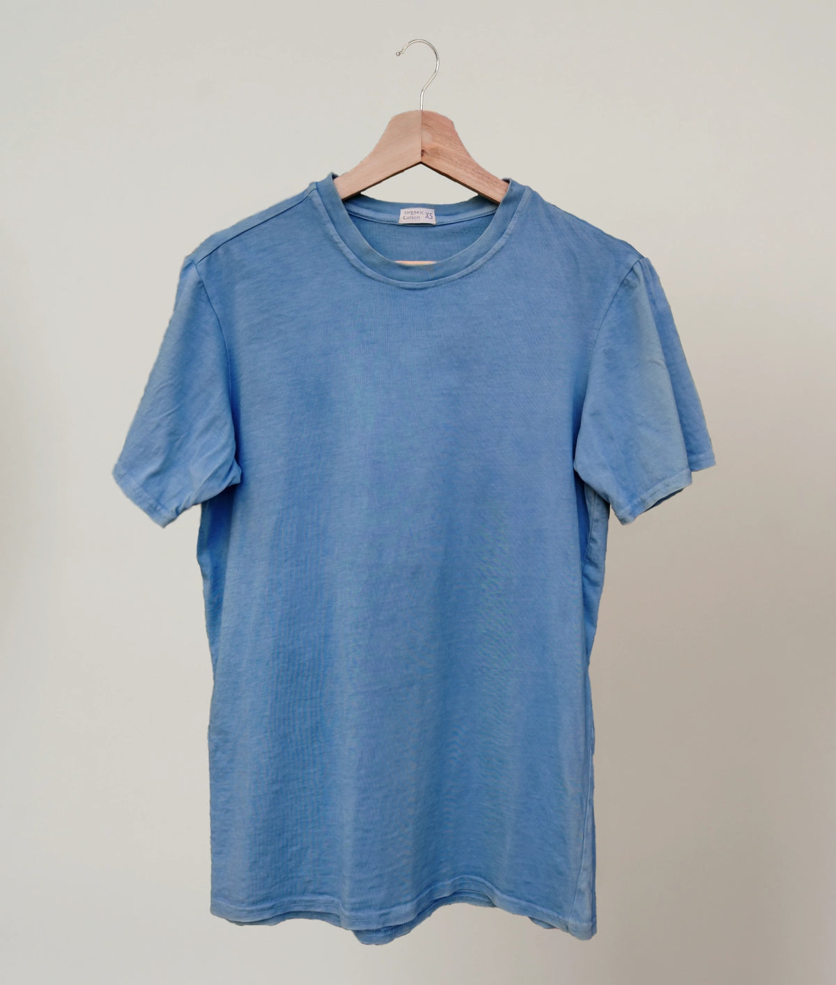 Natural indigo dyed organic cotton T-shirt on plain background.