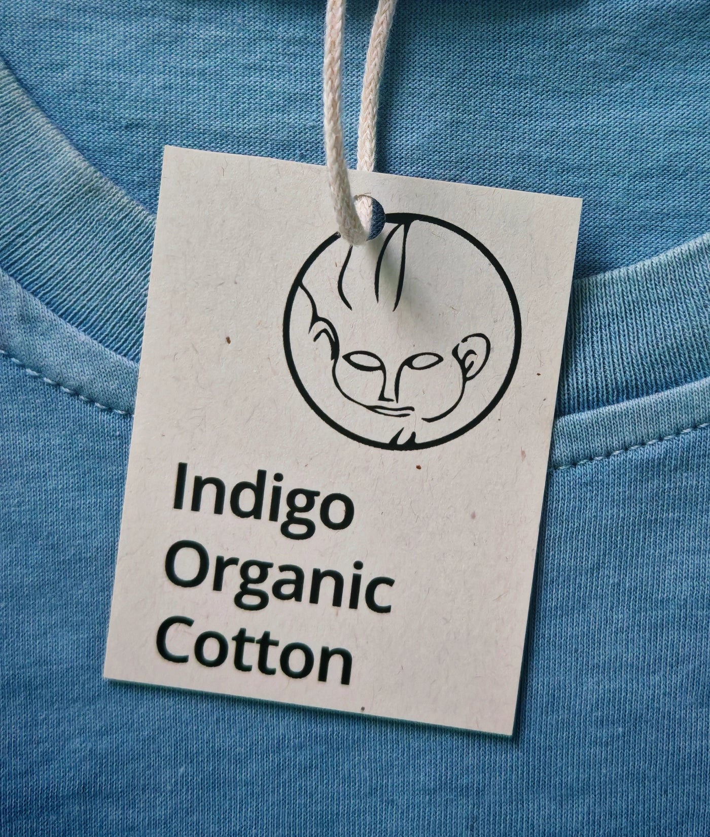 Close-up of a hang tag on a natural indigo dyed organic cotton T-shirt.