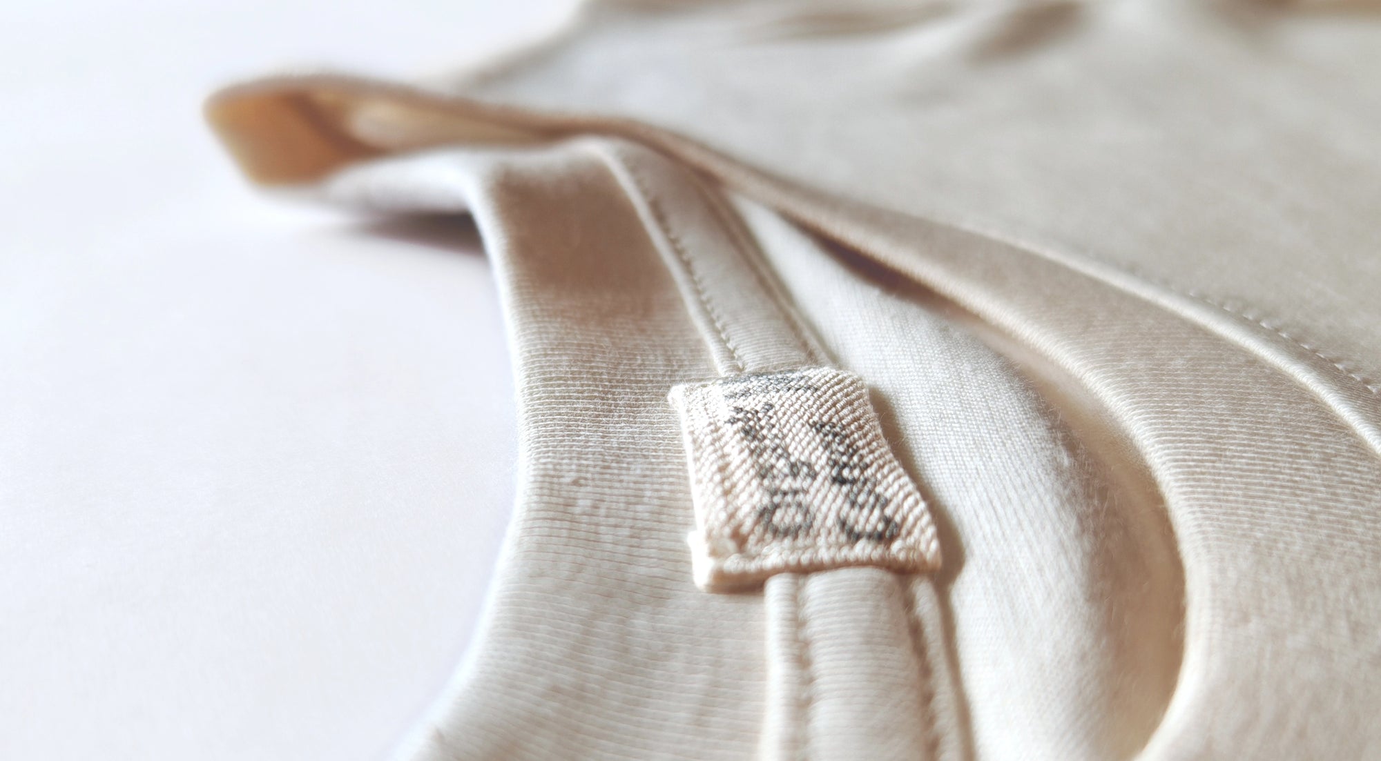 Close-up of hand-printed label on an organic cotton T-shirt, using natural polymer and mineral pigment paint.
